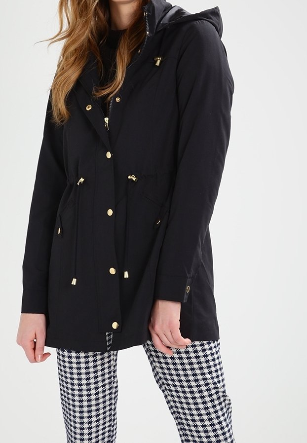 Svart huva jacka med gulddetaljer, elastisk dragsko i midjan och fickdetaljer, matchad med rutiga byxor.