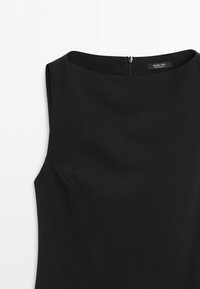 Zwarte mouwloze jurk met boothals en rits aan de achterkant, gemaakt door Massimo Dutti, getoond op een witte achtergrond.
