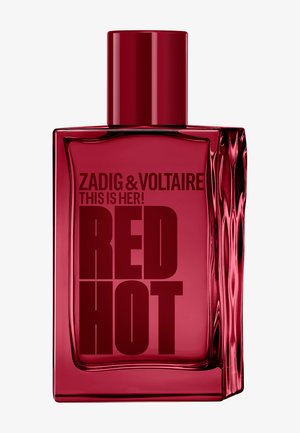 Flacon de parfum rectangulaire translucide rouge avec côté rainuré, étiqueté Zadig & Voltaire This Is Her! RED HOT, avec un bouchon rouge assorti.