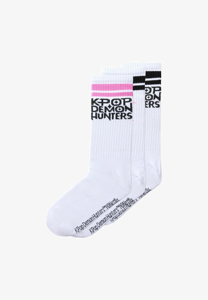 Trois paires de chaussettes blanches type crew avec texte noir "KPOP DEMON HUNTERS" et rayures roses ou noires près du haut, alignées côte à côte.