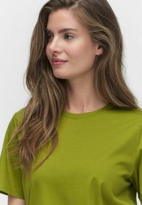 Kortärmad T-shirt med rund hals i ljusgrön bomullstyg. Slät struktur med en enkel design, utan mönster eller detaljer.