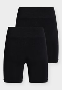 Δύο ζευγάρια απλά μαύρα αδιάκοπα ποδηλατικά σορτς με ψηλή μέση στοιβαγμένα πάνω σε ανοιχτό φόντο.