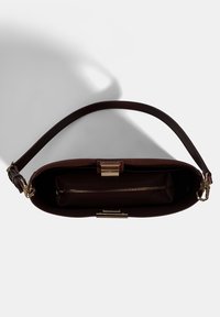 Bordeaux leren handtas met een enkele bovenhandgreep, gouden hardware en een ritsvak aan de binnenkant. Gladde textuur en gestructureerde vorm.