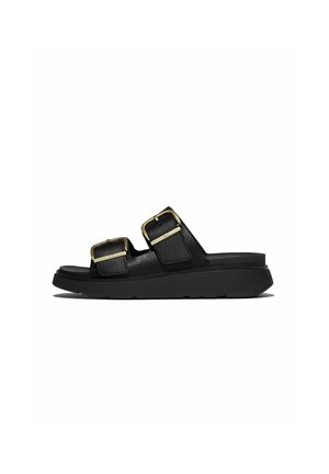 Zwarte slidesandaal met twee brede banden en goudkleurige verstelbare gespen, dikke zool, zijaanzicht op witte achtergrond.