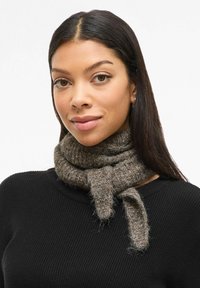 Brown knitted scarf made of soft, textured material, featuring a tied design around the neck and a looped finish.