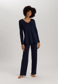 Ensemble de vêtements d'intérieur bleu marine comprenant un haut à manches longues en V et un pantalon assorti, fabriqué dans un tissu doux avec une coupe décontractée.