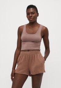 Top cropped marron et shorts texturés assortis, tous deux en tissu doux, avec une coupe décontractée et une taille élastique.