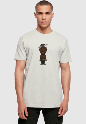 Hellgrau T-Shirt mit einem Cartoon-Charakter, der ein Bandana, kurze Jeans und Stiefel trägt, auf einem männlichen Modell vor einem schlichten Hintergrund präsentiert.