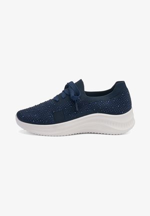 Navy blue knitted sneaker with small sparkling dots, lace-up front, and thick white cushioned sole for casual wear.