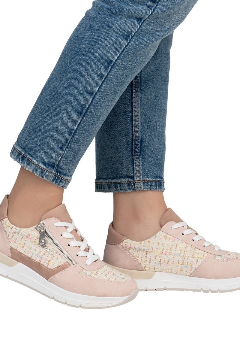 Sneaker rosa chiaro con tomaia in tessuto testurizzato, lacci bianchi e dettaglio con zip laterale. La suola in gomma e i pannelli a contrasto completano il design.