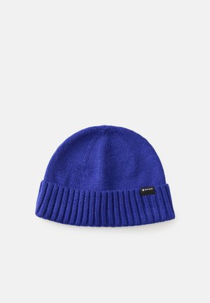 Knit beanie in bright blue, featuring a ribbed cuff, textured body, and a small black label on the side. Soft, warm material.
