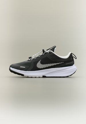 Μαύρο-άσπρο παπούτσι για τρέξιμο Nike με λευκή σόλα, ρίγα με το λογότυπο Swoosh, θηλιά στη φτέρνα και χαρακτηριστικό αντοχής στις πιτσιλιές στο πλάι.