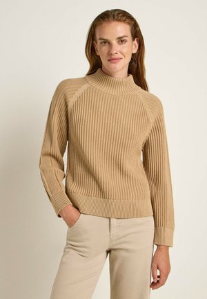 Beige, ribbeliger Strickpullover mit hohem Kragen und langen Ärmeln. Die Textur ist weich und hat einen taillierten Saum sowie Raglanärmel für eine entspannte Passform.