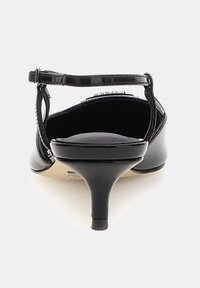 Black patent leather high heel shoe with a pointed toe, slim ankle strap, and a delicate stiletto heel. Smooth texture and sleek design.