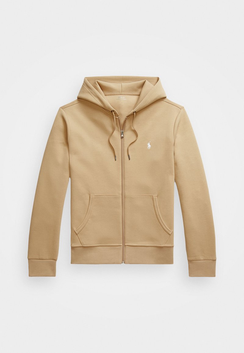 Sweat à capuche zippé beige avec une capuche en couches et des cordons de serrage, poches avant, poignets côtelés et un petit logo blanc sur la poitrine. Texture lisse.