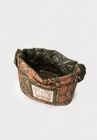 Grüne Tasche mit Blumenmuster und gesticktem Patch, ausgestattet mit einem Klappenverschluss und einem verstellbaren Tragegurt. Innenfutter mit Markenlogo.