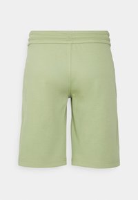 Pantaloni corti verde chiaro fino al ginocchio con cintura elastica e cuciture visibili su sfondo bianco.