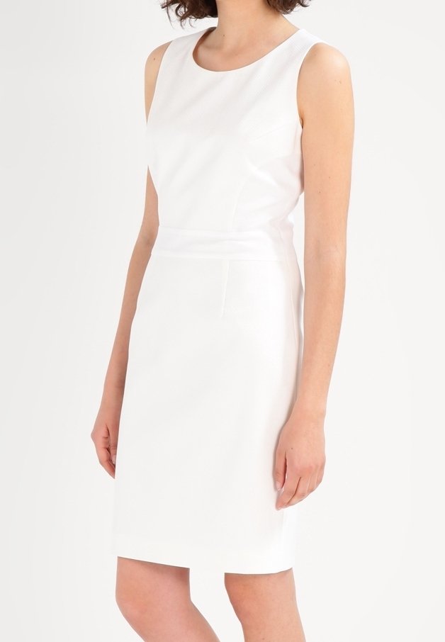 Robe blanche sans manches avec un col rond, une silhouette ajustée, un tissu texturé et une poche latérale. Design à hauteur du genou avec une finition lisse.