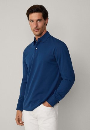Langarm-Polohemd in tiefblau, aus glattem Baumwollstoff. Verfügt über einen klassischen Kragen, eine Drei-Knopf-Leiste und seitliche Taschen.
