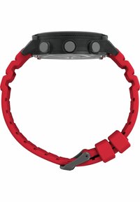 Digitális óra fekete számlappal, piros cikk-cakk szíjjal, texturált gombokkal és kétrészes csattal. Sleek, kör alakú dizájnnal rendelkezik.