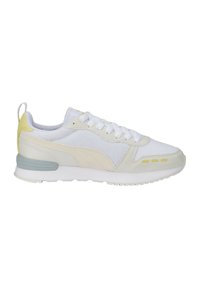 Hvide atletiske sneakers med mesh og ruskindsmaterialer, et let design, accentfarver i bleg gul og grå, samt en tekstureret sål.
