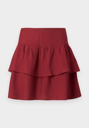 Gelaagde rok in diep bordeauxrood, met een brede tailleband, gestructureerde ruffles op de lagen en een zachte, textuurstof.