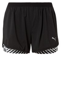 Svarta idrottsshorts med elastisk midja, tillverkade av ett lätt material, och ett randigt mönster i svart och vitt vid fållen.