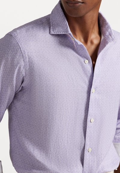 Chemise button-up violet clair avec un petit motif répétitif. Présente un col pointu et une fermeture classique à boutons, fabriquée en tissu texturé.