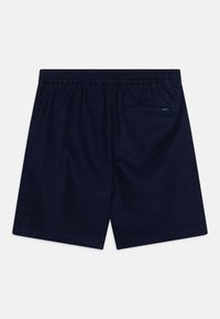 Pantaloni da bagno blu navy con vita elastica, tasca posteriore e dettagli di cucitura all'orlo. Realizzati in tessuto leggero e ad asciugatura rapida.