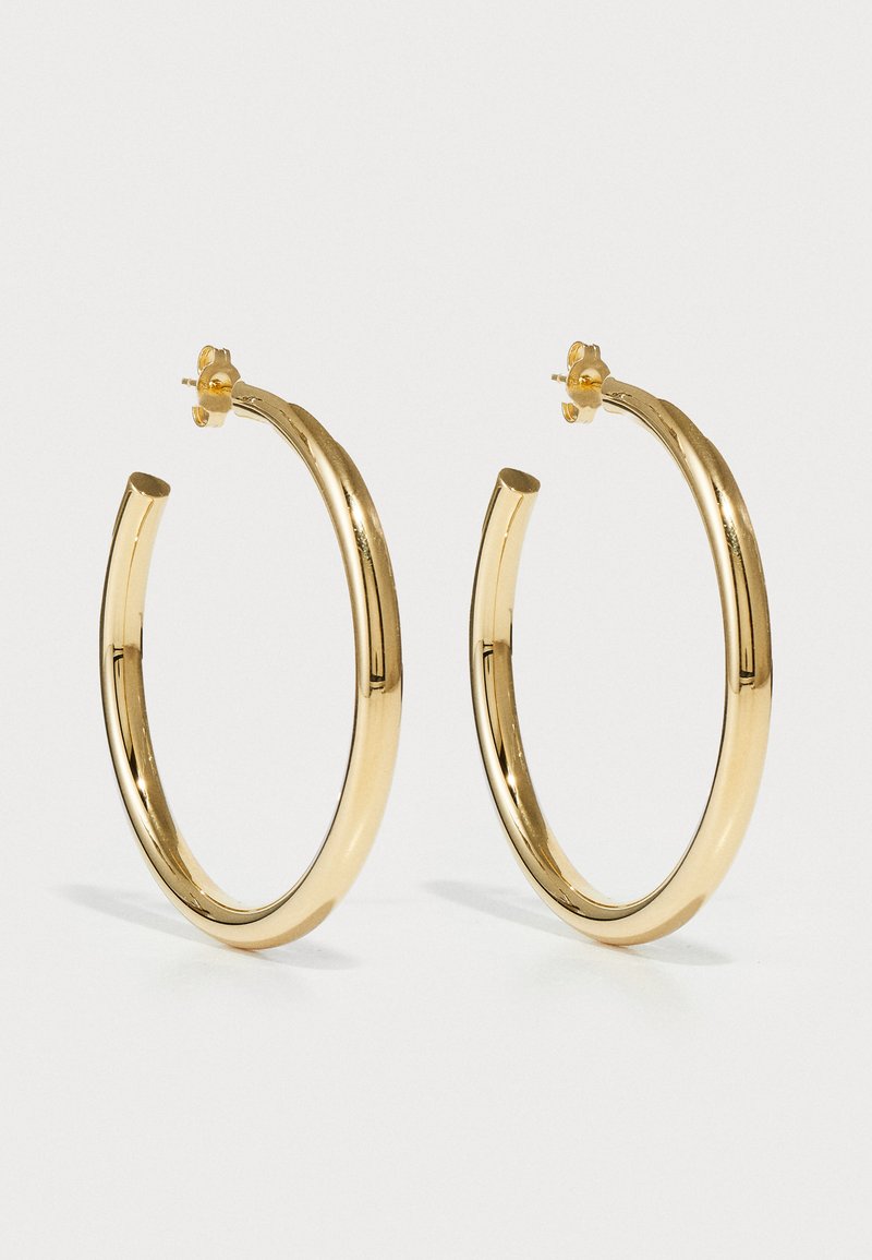 Goldene Creolen mit einem glatten, abgerundeten Design. Polierte Oberfläche und sichere Steckverschluss. Hat einen Durchmesser von etwa 5 Zentimetern.