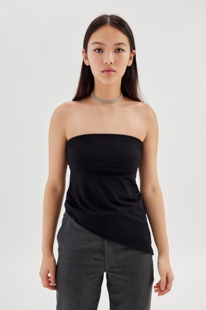 Zwarte strapless top van rekbaar materiaal met een getailleerde bodice en asymmetrische zoom, gecombineerd met grijze gestreepte broek. Zilveren chokeraccessoire.
