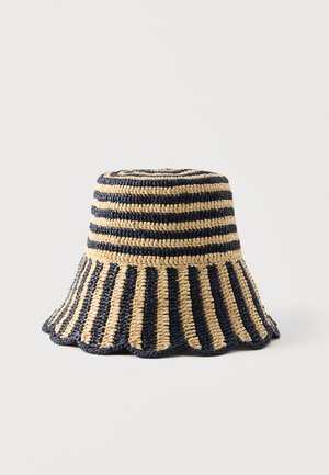 Crocheted bucket hat with alternating navy and beige stripes, featuring a flat top and a scalloped wide brim.