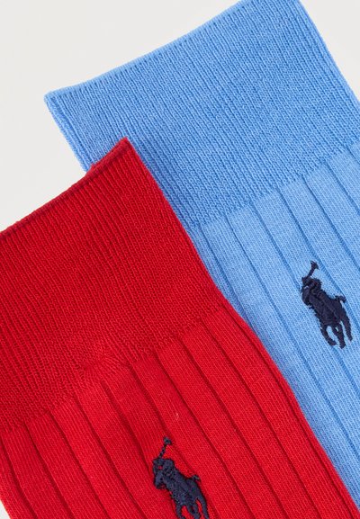 Ζευγάρια ριγωτών βαμβακερών κάλτσων, μία κόκκινη και μία ανοιχτό μπλε, καθεμία με μικρό μαύρο κεντημένο λογότυπο παίκτη πόλο.