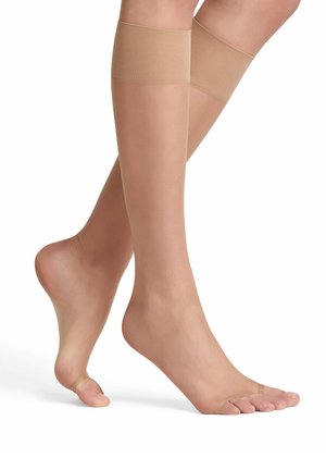 Beige doorschijnende beenwarmers met een transparante afwerking, voorzien van een brede elastische band aan de bovenkant en een open teenontwerp voor ademend vermogen.