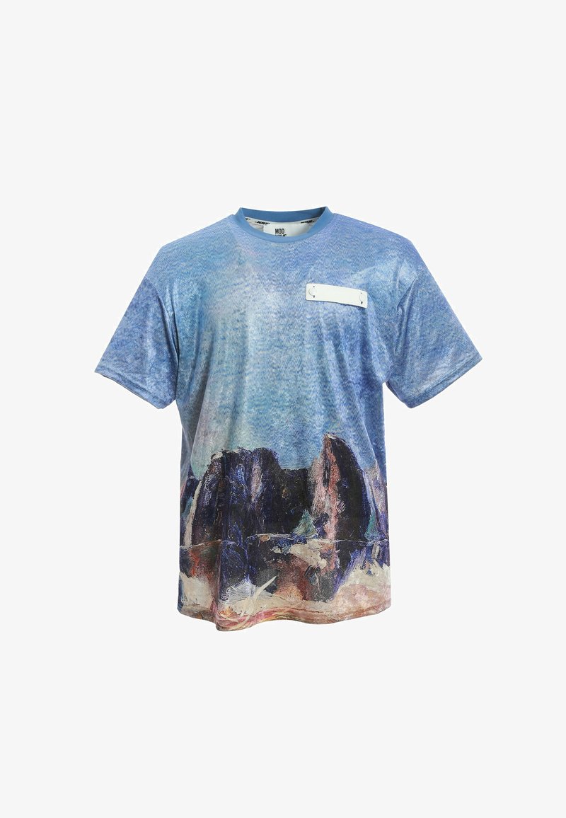 Camiseta gráfica de mezcla de algodón. Presenta un diseño abstracto en azul con formas rocosas oscuras en la parte inferior y un parche blanco con acentos metálicos.