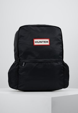 Sort rektangulær rygsæk med sidelommer og et forlap mærket HUNTER med sort tekst på hvid baggrund med en rød kant.