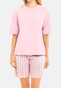 Ljust rosa t-shirt med kort ärm, kombinerad med pastellrandiga shorts i vitt, rosa och grått med vertikala ränder, tillverkade av mjukt bomullsmaterial.
