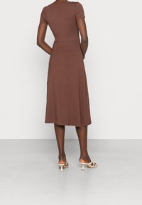 Kaffebrunt kortärmad klänning med figurnära midja och en utsvängd midiklänning, tillverkad av ett mjukt, strukturerat tyg, med rundad halsringning.