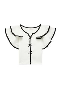 Top bianco a maniche corte con bordi neri, scollo a V e maniche a volant. Presenta fiocchi neri decorativi lungo il centro. Tessuto texturizzato.