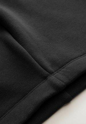 Schwarzer Stoff mit einer glatten Textur, der genähte Nähte und einen leichten Stretch aufweist. Das Design ist einfach und minimalistisch.