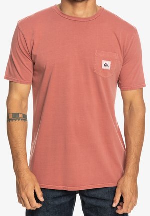 Short-sleeve, crew neck t-shirt in dusty rose, cotton material. Front pocket features a small logo patch; casual fit with a smooth texture.