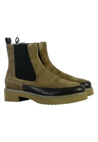 Botas de tobillo de ante marrón con paneles laterales de elastano negro y una puntera de cuero negro. Suelas de goma gruesa en crema con un patrón de relieve visible.