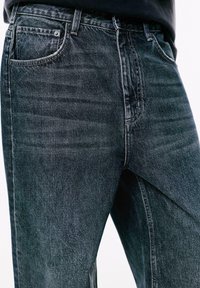 Jeans din denim gri închis cu un design clasic cu cinci buzunare, croi drept și decolorare subtilă; realizate dintr-o țesătură de bumbac rezistentă.
