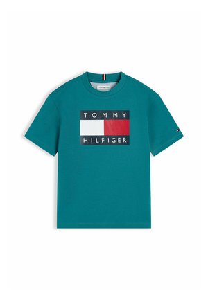 Turkusowa koszulka z krótkim rękawem z dużym logo Tommy Hilfiger w kolorach białym, czerwonym i granatowym na piersi oraz z małym logo na lewym rękawie.