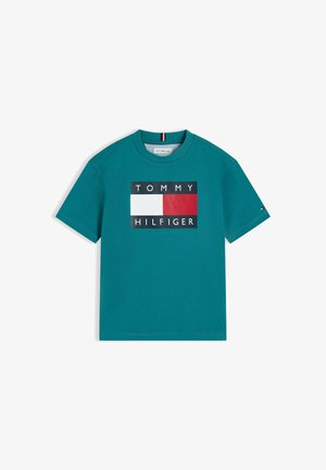 Turkusowa koszulka z krótkim rękawem z dużym logo Tommy Hilfiger w kolorach białym, czerwonym i granatowym na piersi oraz z małym logo na lewym rękawie.