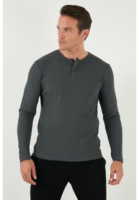 Sötétszürke, hosszú ujjú henley póló, textúrált anyagból. Kerek nyakkivágással és két gombos záródással rendelkezik a nyakrésznél. Slim fit fazon.
