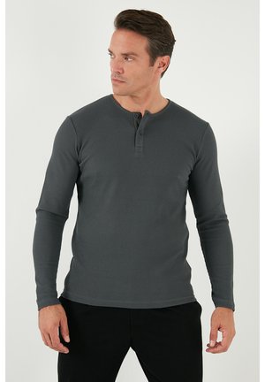 Dark gray long-sleeve henley shirt with a textured fabric. Features a rounded neckline and two-button closure at the collar. Slim fit design.