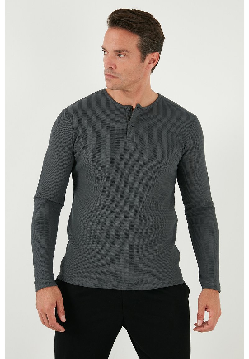 Sötétszürke, hosszú ujjú henley póló, textúrált anyagból. Kerek nyakkivágással és két gombos záródással rendelkezik a nyakrésznél. Slim fit fazon.