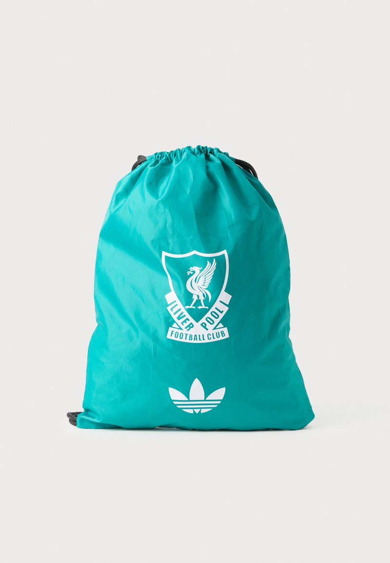 Bolsa de cuerda en color verde azulado hecha de material ligero, con un logo blanco del Liverpool Football Club y un emblema blanco de Adidas en la parte inferior.