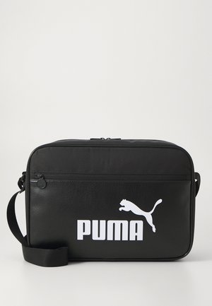 Juoda odinė rankinė stačiakampio formos, su priekiu užtrauktuko kišene ir dideliu baltu "PUMA" logotipu su pašokusia katės dizainu.